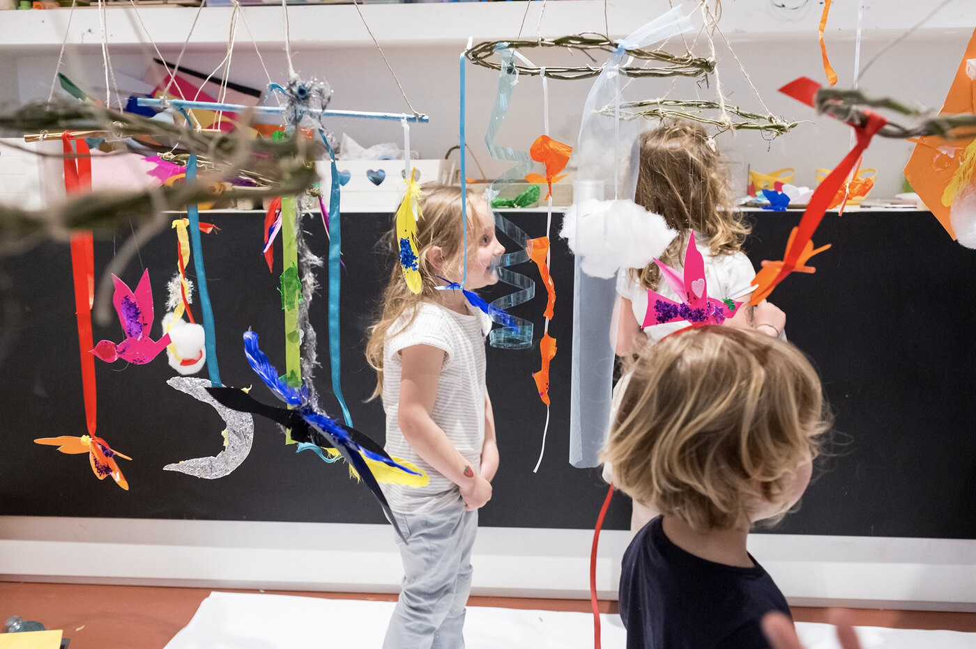 Bambini attraversano un’installazione artistica sospesa nell’atelier Tomorò